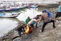 Petugas kepolisian dibantu nelayan mengevaluasi jenazah korban. Diketahui korban merupakan warga Tulungagung yang sempat dikabarkan hilang setelah pamit mancing di Pantai Simbaronce Kabupaten Trenggalek.