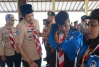 Saat Wakil Bupati Trenggalek Syah Muhammad Natanegara yang juga merupakan Ketua Kwartir Cabang (Kakwarcab) Gerakan Pramuka Trenggalek memakaikan jaket pada perwakilan peserta yang akan diikutkan dalam gelaran Raimuna 2023. 