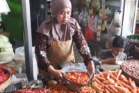 Salah satu pedagang di pasar basah Trenggalek tengah menimbang cabai pembeli