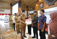Wakil Bupati Trenggalek Syah Muhammad Natanegara memberikan bingkisan pada keluarga disabilitas yang baru saja mendapatkan edukasi dari Prof. Dr. Soeharso Surakarta