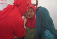 Ketua Ketua Tim PKK Trenggalek Novita Hardini (baju biru) dampingi seorang nenek periksa kesehatan mata