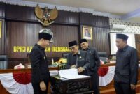 Ketua DPRD Trenggalek menyerahkan pengesahan empat Perda ke Bupati Trenggalek usai ditandatangani bersama di depan peserta rapat Paripurna di gedung DPRD Trenggalek