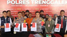 Kapolres Trenggalek, AKBP Gathut Sunu Sipriyono (tengah) menunjukkan barang bukti penipuan berkedok jual beli mobil berikut tersangkanya, di Mapolres Trenggalek