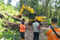 Alat Berat singkirkan material longsor di Km 15 Jalan Trenggalek-Bendungan, Desa Surenlor, Kecamatan Bendungan.
