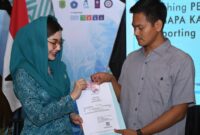 Ketua PKK Trenggalek, Novita Hardini memberikan akte kelahiran pada masyarakat usai launching tiga layanan masyarakat di Pendopo Manggala Praja Nugraha Kabupaten Trenggalek. (Foto : Prokopim Trenggalek)