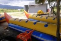 Ilustrasi Banana Boat yang tengah terparkir di tepi pantai 