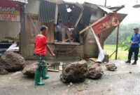 Tim BPBD tengah berupaya memindahkan bongkahan batu yang berceceran di badan jalan