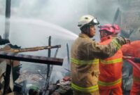 Damkar Trenggalek tengah berupaya memadamkan api yang membakar dapur warga Desa Sugihan, Kecamatan Kampak.