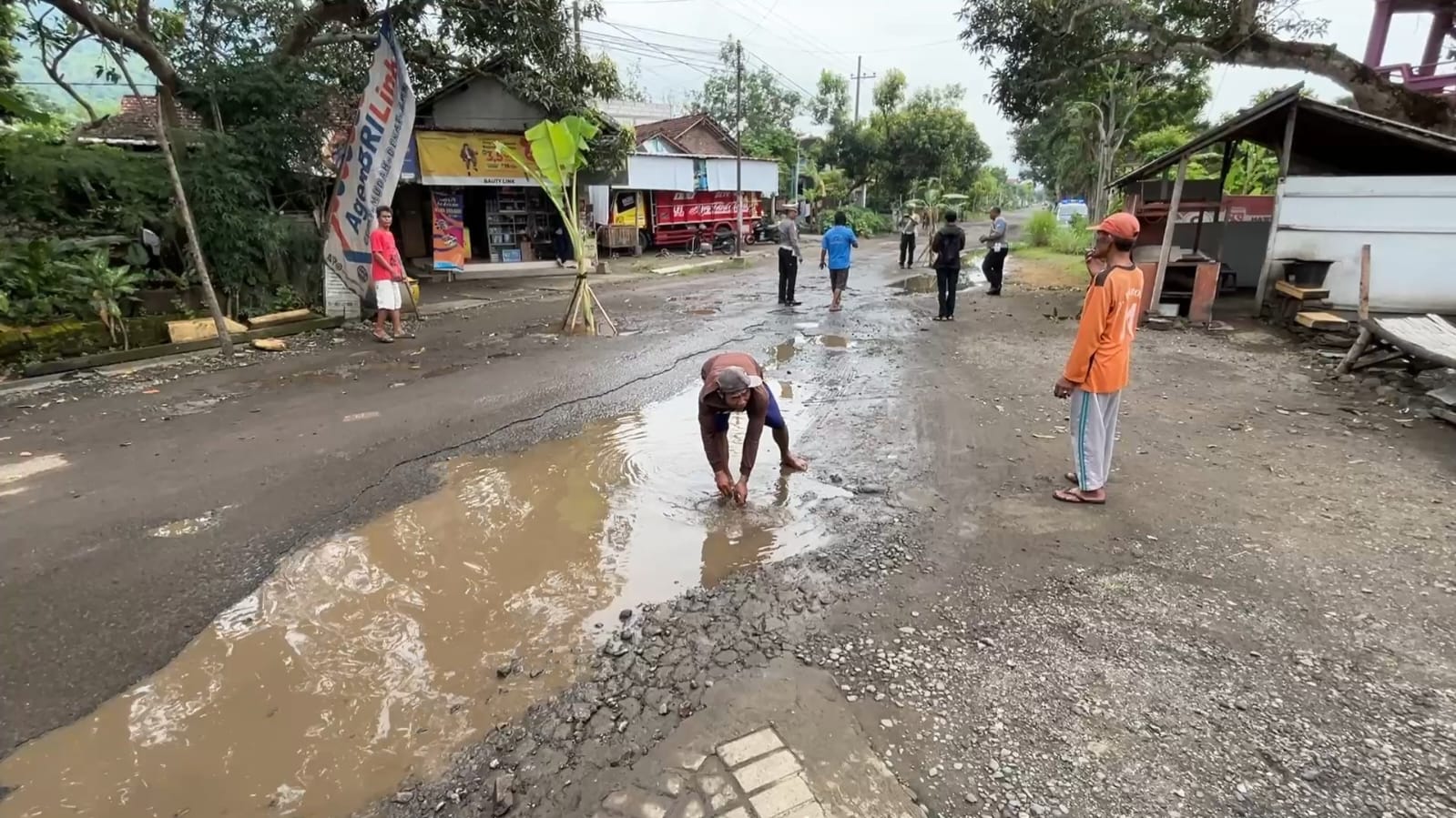 Kondisi jalan diperparah dengan adanya genangan air, sehingga jalan rusak tidak nampak.