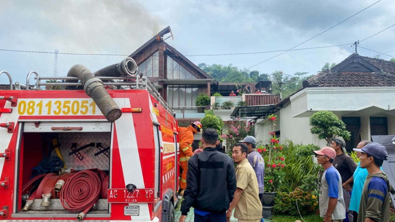 Damkar Trenggalek tengah berusaha memadamkan api yang melahap rumah kayu di Karangrejo, Kampak.