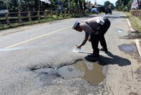 Anggota satlantas Polres Trenggalek tandai jalan rusak di sepanjang ruas jalan nasional Trenggalek-Tulungagung.