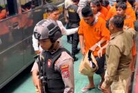 Tersangka perusakan Polsek Watulimo tiba di Kejari Trenggalek setelah menempuh perjalanan dari Polda Jatim, Kamis (20/3/2025).