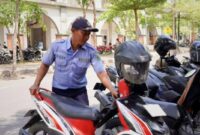 Petugas Dinas Perhubungan Kabupaten Trenggalek tengah merapikan kendaraan roda dua yang terparkir di seputaran Pasar Pon.