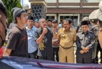 Ketua Komisi IV DPRD Trenggalek, Sukarodin berbicara di depan masa GMNI Trenggalek.