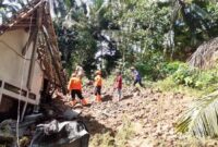 Tim gabungan berusaha membersihkan material longsor yang menimpa rumah Yamin, di Desa Sobo Kecamatan Munjungan, Kabupaten Trenggalek.