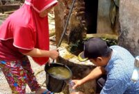 Warga Dusun Krajan, Desa Prambon, Kecamatan Tugu Trenggalek menimba air untuk dimasukkan kedalam botol sebagai sampling air tercemar.