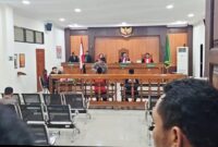 Masduki (rompi orange) dan Faisol (baju biru) mendengarkan pembacaan dakwaan dari JPU saat sidang di Pengadilan Negeri Trenggalek, Kamis (20/11/2025). (Foto : Sofyan Arif Chandra)