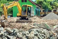 Alat berat terlihat meratakan bangunan bekas perpustakaan SDN 1 Kamulan yang dialihfungsikan menjadi Koperasi Desa Merah Putih (KDMP), setelah keputusan musyawarah desa bersama pihak sekolah dan masyarakat. 