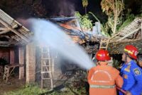Damkar Trenggalek berusaha padamkan api yang membakar bagian atap tempat pembakaran genting milik Miftahul Huda, warga Dusun Widoyoko, Desa Kamulan, Kecamatan Durenan, Trenggalek.