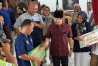 Bupati Trenggalek Mochamad Nur Arifin sangoni bapak Ali Murtadlo sebelum diberangkatkan menuju Sidrap dalam program Transmigrasi tahun 2025.
