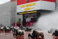 Puluhan personel Polres Trenggalek sujud syukur dan disiram air saat upacara kenaikan pangkat di halaman Polres Trenggalek, Rabu (31/12/2025).