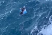 Lima kru kapal KM Natasya 01 berusaha ditarik menggunakan tali dari tebing di perairan selatan Watulimo Trenggalek.