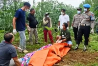 Petugas tengah memasukan jenazah Nandim (80) kedalam kantong jenazah untuk dibawa ke visum di faskes terdekat. (Foto : Istimewa)