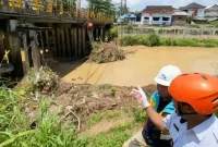 Kepala Pelaksana BPBD Trenggalek, Triadi Admono tunjukkan sedimen yang menumpuk di penyangga jembatan Ngasinan.