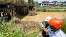 Kepala Pelaksana BPBD Trenggalek, Triadi Admono tunjukkan sedimen yang menumpuk di penyangga jembatan Ngasinan.