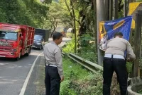 Anggota Satlantas Polres Trenggalek pasang rambu peringatan di lokasi rawan longsor.
