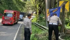 Anggota Satlantas Polres Trenggalek pasang rambu peringatan di lokasi rawan longsor.