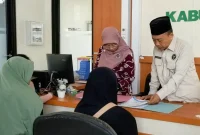 Subkan Hamzah (pakai peci) dampingi urus administrasi di kantor Kementerian Kementerian Haji dan Umrah Trenggalek.