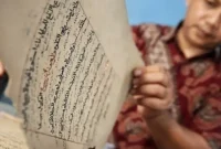 Harmadji perlihatkan manuskrip kuno miliknya usah di bersihkan atau dijamas. (Foto: Antara/Destyan Sujarwoko)