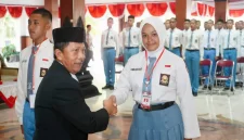 Pj. Sekda Trenggalek Triadi Admono jabat tangan perwakilan calon Paskibraka usai sematkan pin tanda dimulainya pelatihan.