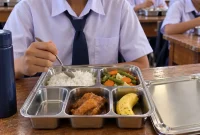 Ilustrasi siswa menyantap menu Makan Bergizi Gratis (MBG) di lingkungan sekolah.