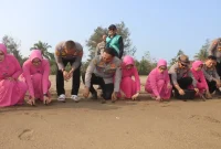 Kapolres Trenggalek AKBP Rizky Tri Putra Erryka Adi Wijaya bersama istri, Ny. Debie Rizky, saat melepasliarkan tukik di Pantai Kili-Kili, Kecamatan Panggul, Kabupaten Trenggalek.