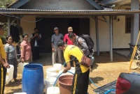 Petugas Polsek Bendungan menyalurkan air bersih kepada warga Desa Masaran, Kabupaten Trenggalek, melalui program Patroli Gentong di tengah kemarau panjang.