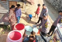 Petugas Patroli Gentong Polres Trenggalek menyalurkan air bersih kepada warga yang terdampak kekeringan.
