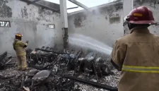 Petugas Damkar melakukan pembasahan di lokasi kebakaran showroom Arik Motor di Desa Sumurup, Kecamatan Bendungan, Trenggalek, Rabu (21/10/2026).