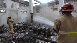 Petugas Damkar melakukan pembasahan di lokasi kebakaran showroom Arik Motor di Desa Sumurup, Kecamatan Bendungan, Trenggalek, Rabu (21/10/2026).