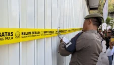 Petugas Satpol PP Kabupaten Trenggalek memasang garis pembatas dan menyegel gerai minuman keras Sari Jaya di Kelurahan Ngantru, Kecamatan Trenggalek.